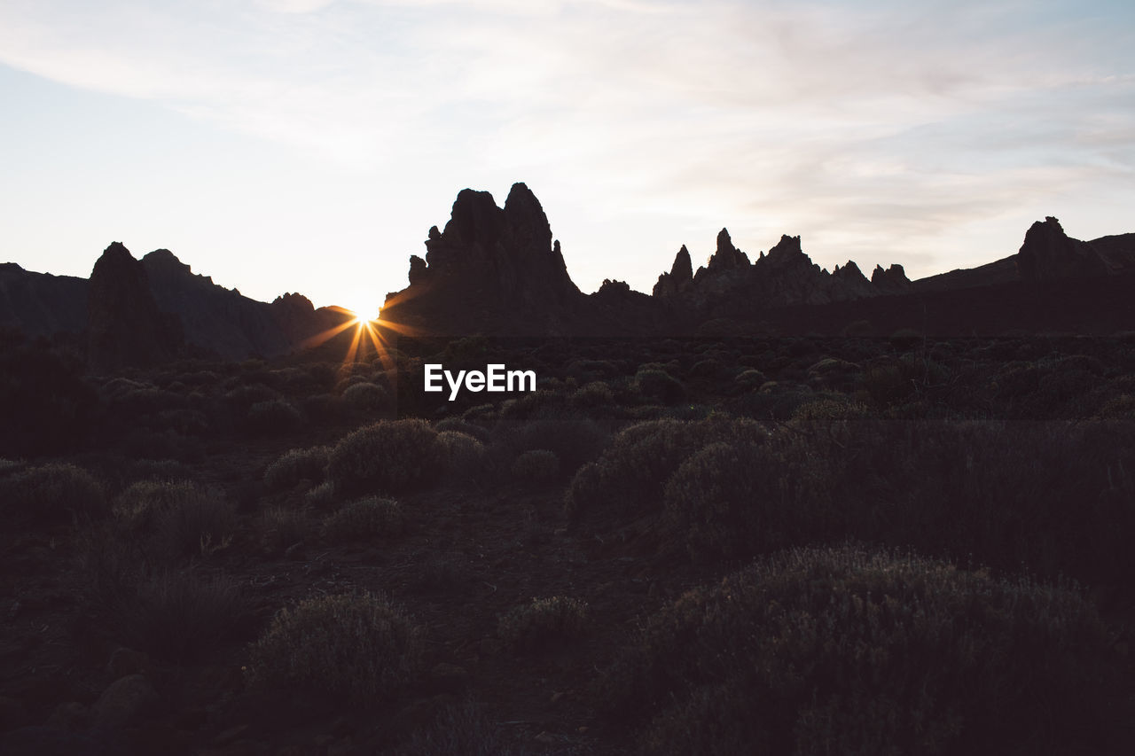 Scenic view of silhouette mountains against sky during sunset