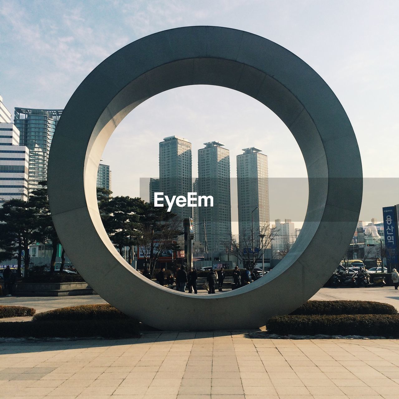 Skyscrapers seen through circular structure against sky