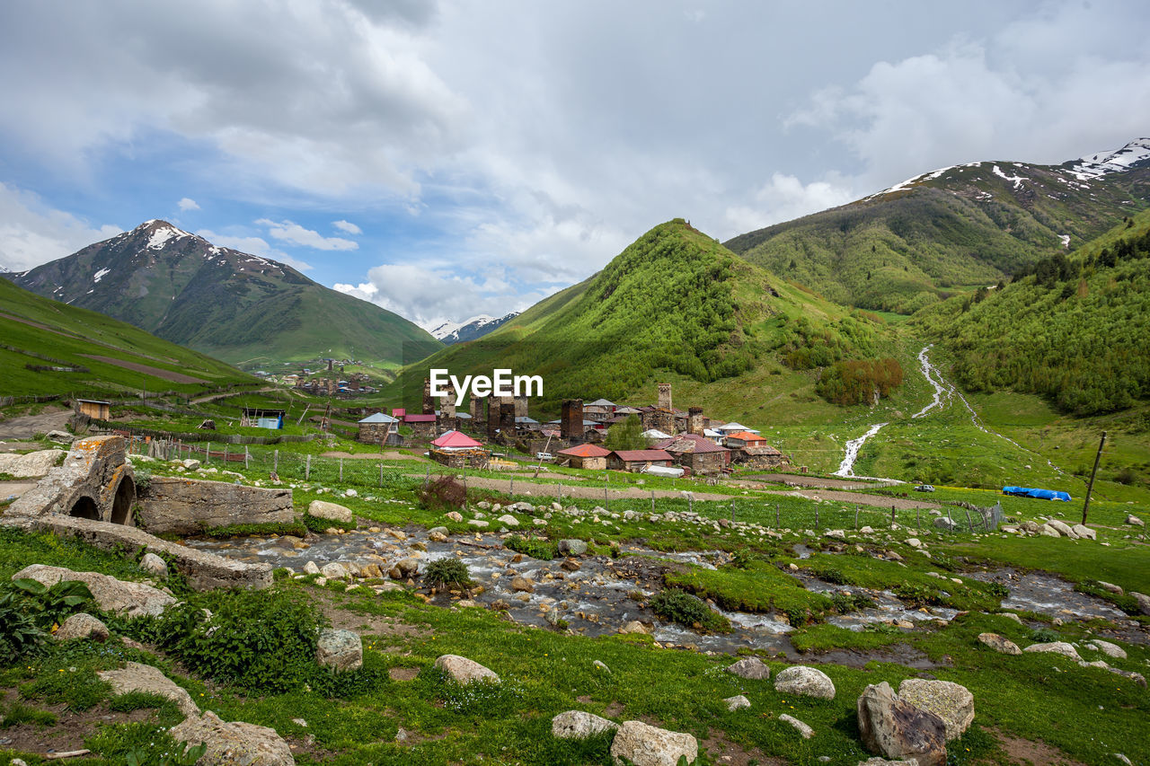 SCENIC VIEW OF MOUNTAINS AND BUILDINGS AGAINST SKY