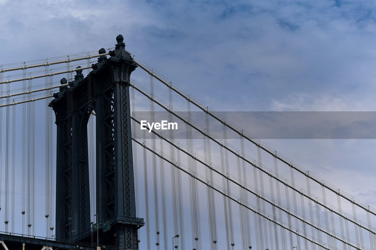 LOW ANGLE VIEW OF BRIDGE BY BUILDING AGAINST SKY