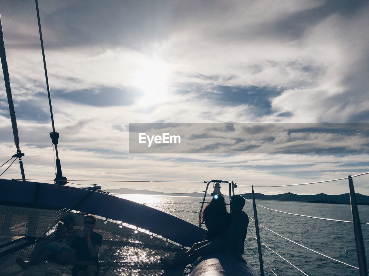 LOW SECTION OF WOMAN ON SEA AGAINST SKY