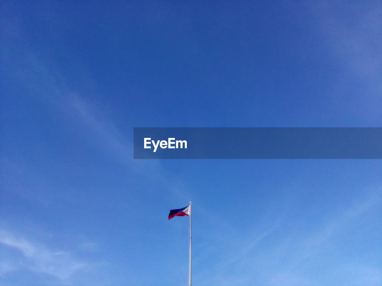 Low angle view of flag against blue sky