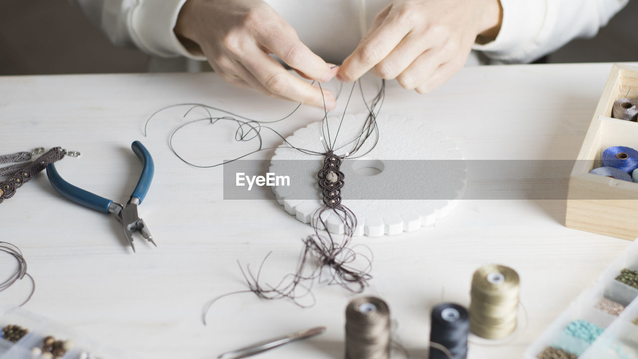 High angle view of woman working with thread on table