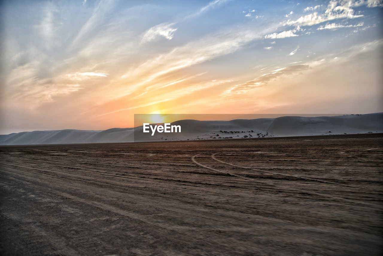 Scenic view of desert against sky during sunset