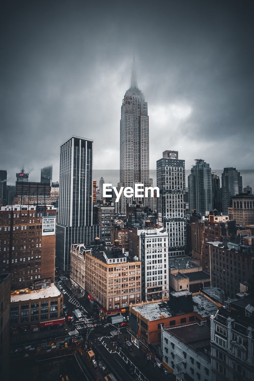 Skyscrapers in city against cloudy sky
