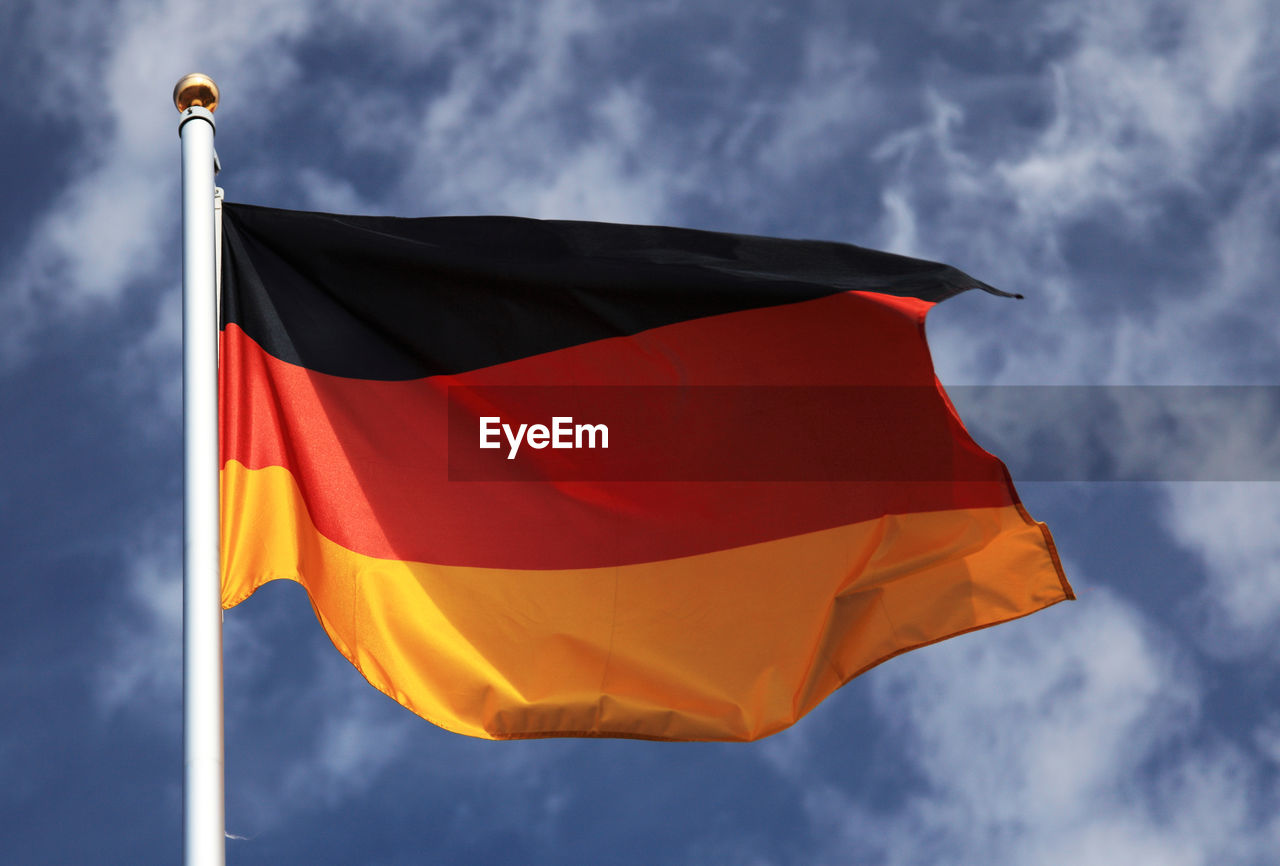 Low angle view of german flag waving against sky