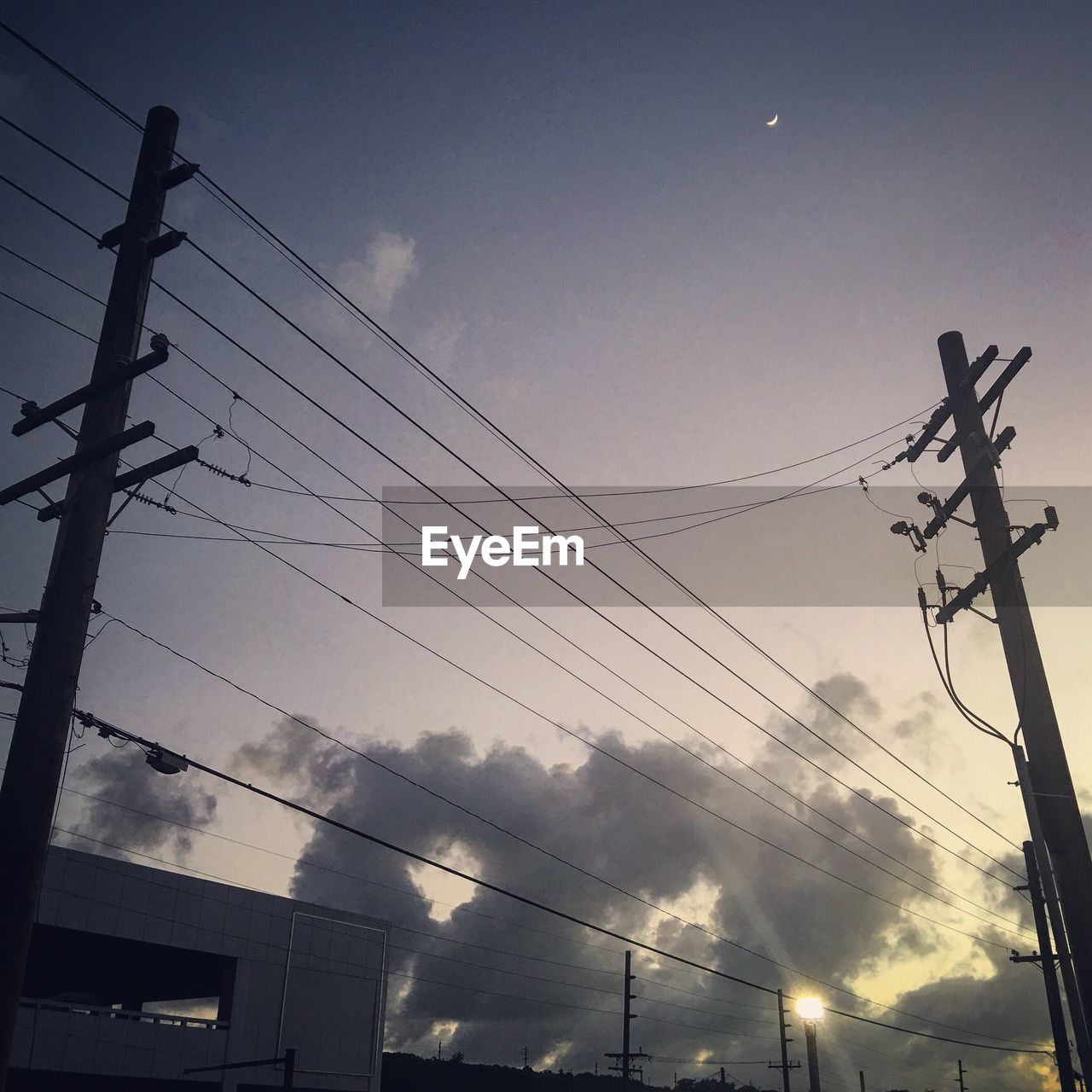 LOW ANGLE VIEW OF POWER LINES AGAINST CLOUDY SKY