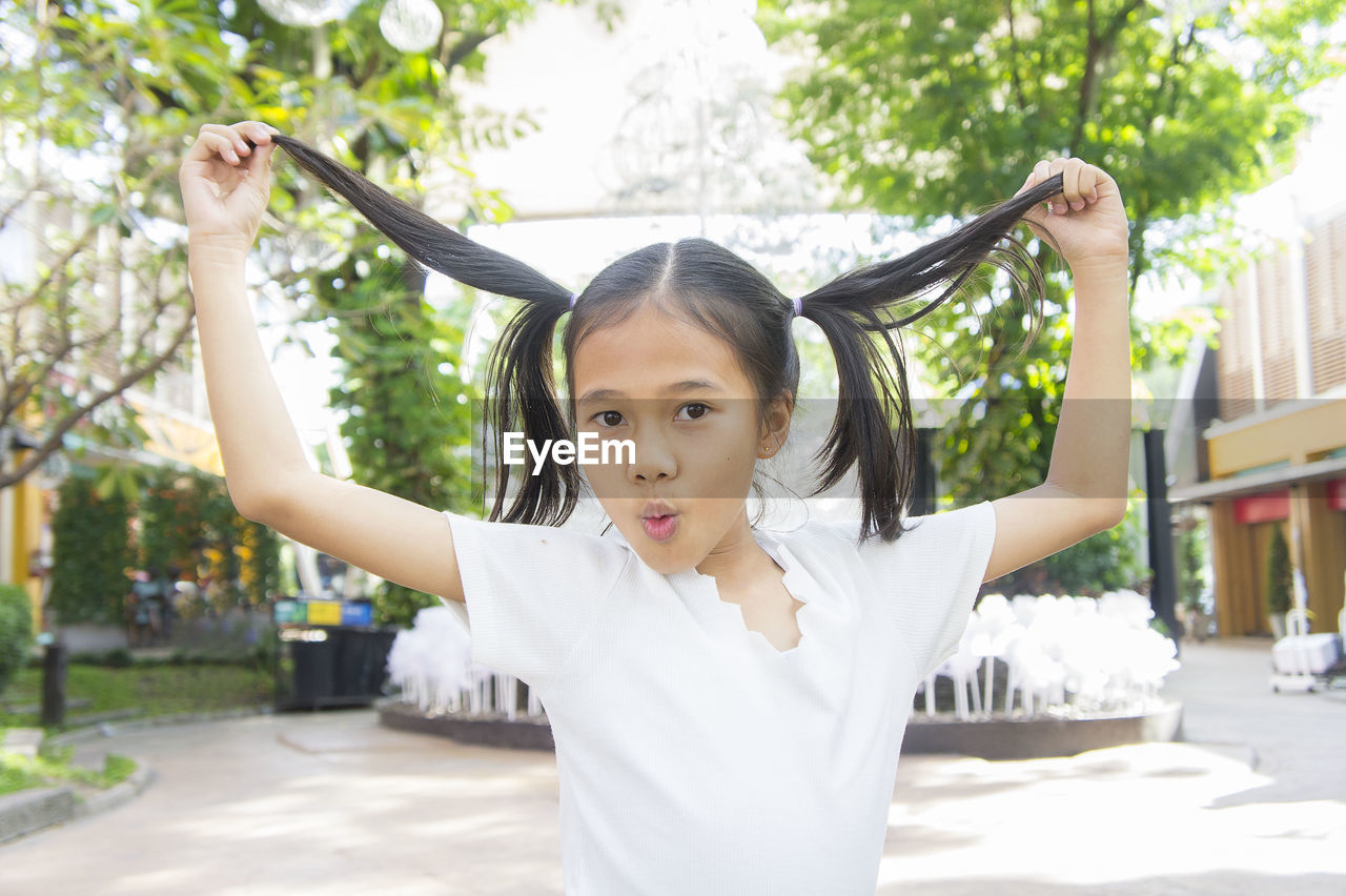Portrait of happy girl standing in park