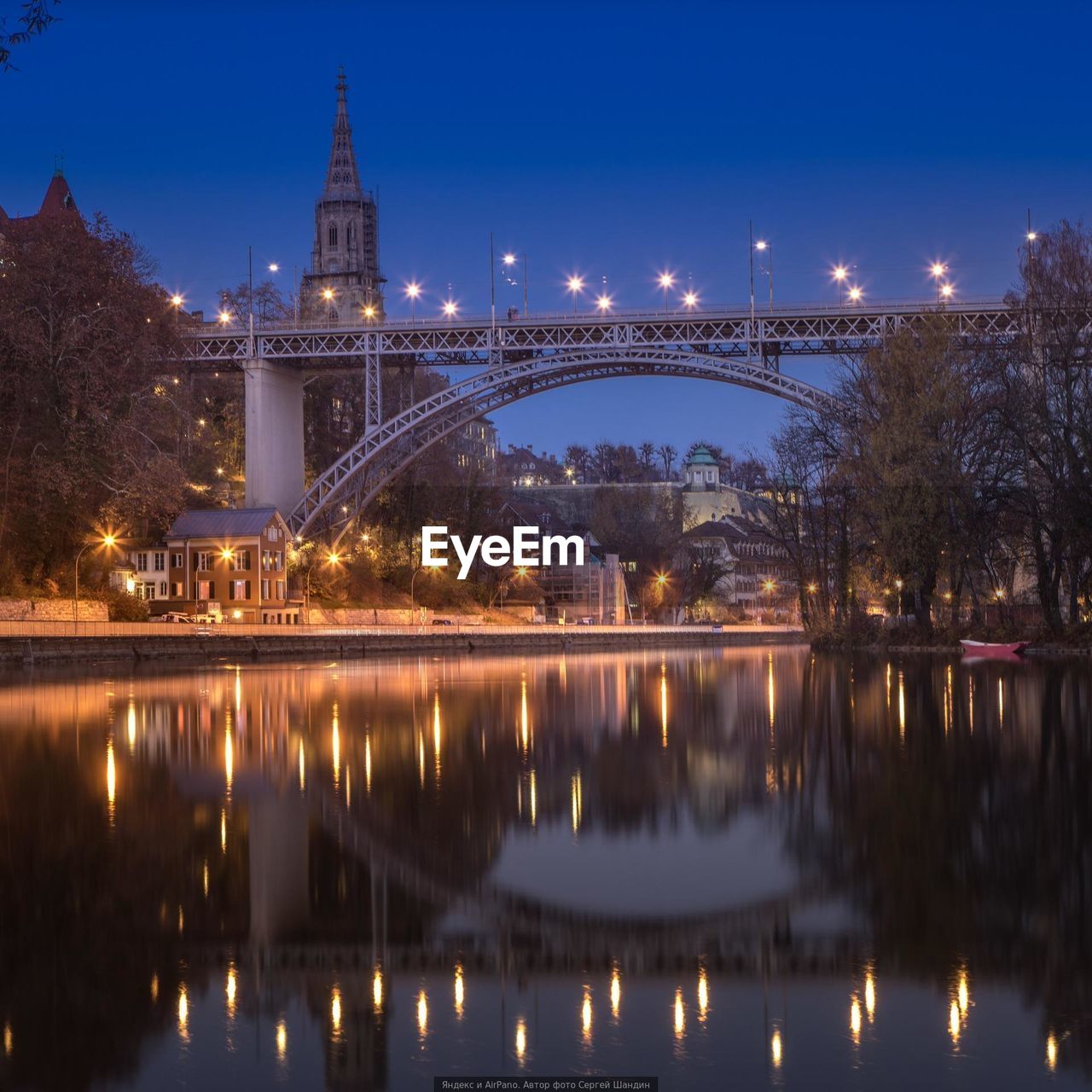 Illuminated bridge over river at night