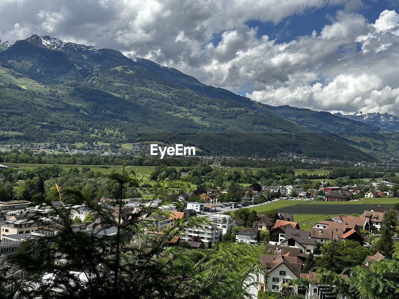 mountain, mountain range, environment, landscape, architecture, building, cloud, scenics - nature, sky, building exterior, plant, nature, built structure, tree, land, house, beauty in nature, residential district, rural area, village, valley, city, no people, rural scene, town, travel destinations, outdoors, field, travel, day, agriculture, tourism, aerial photography, high angle view, tranquility, social issues, green, forest, tranquil scene