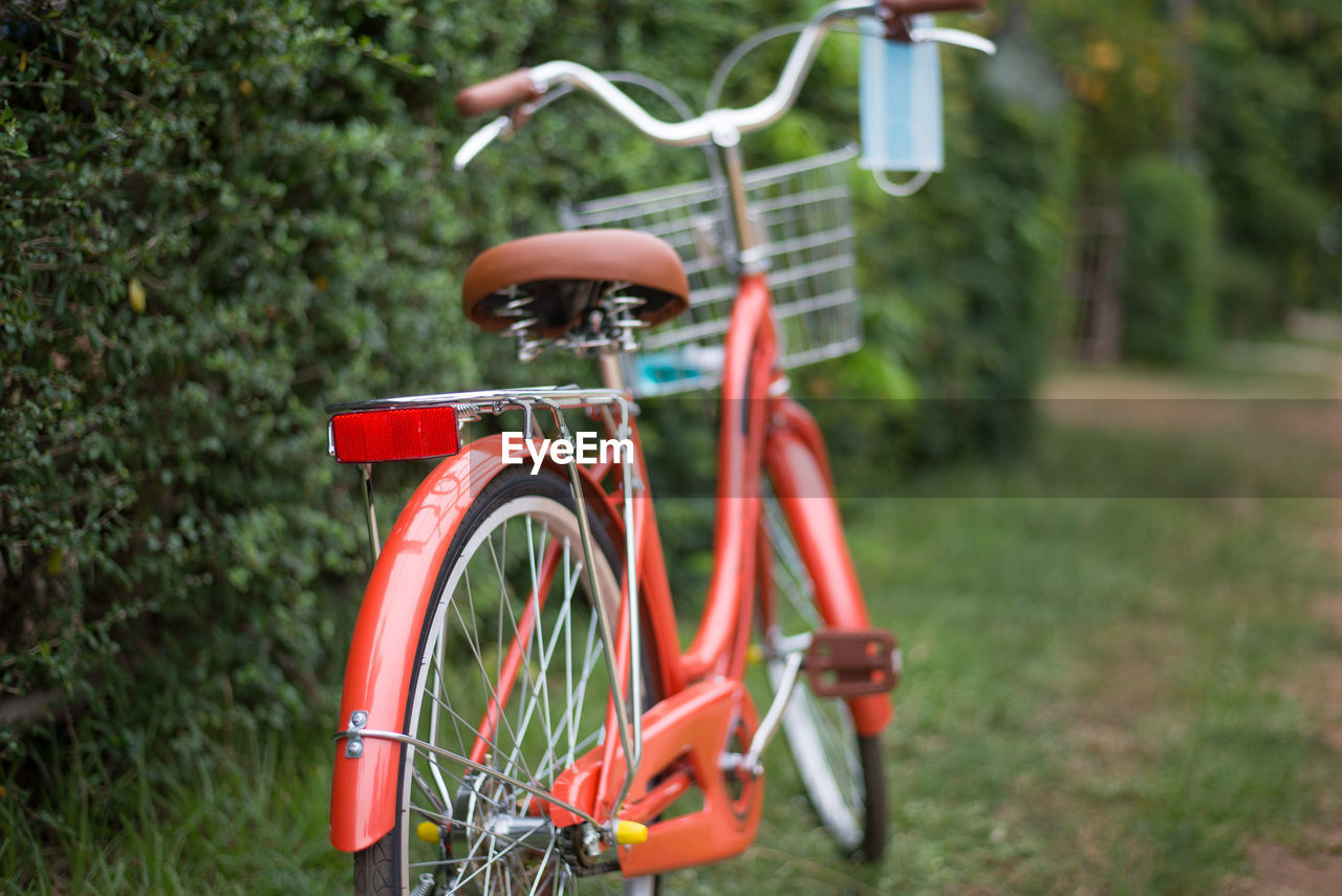 Bicycle with protective face mask hanging parked on field