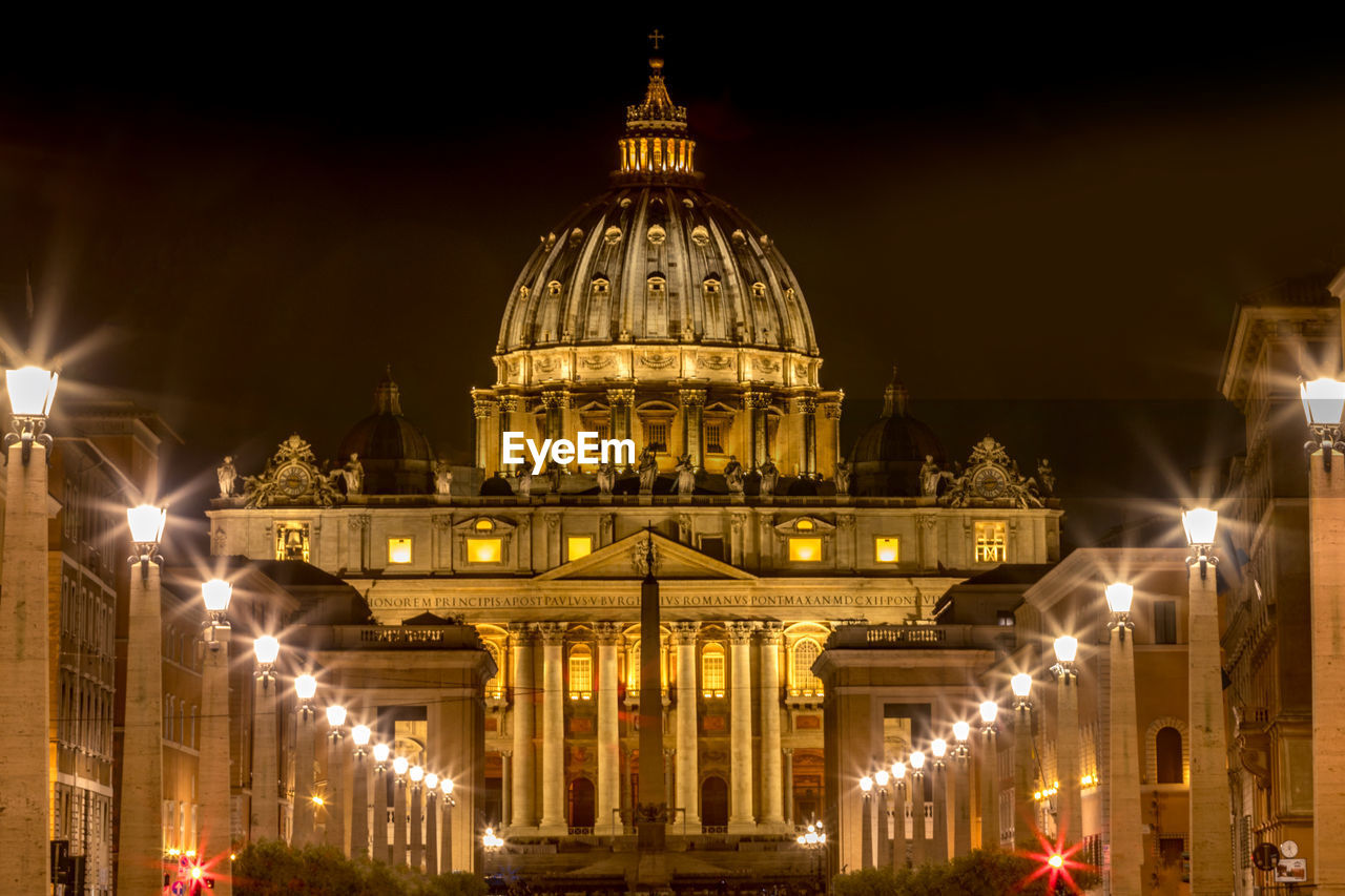 Illuminated st peters basilica against sky in city at night
