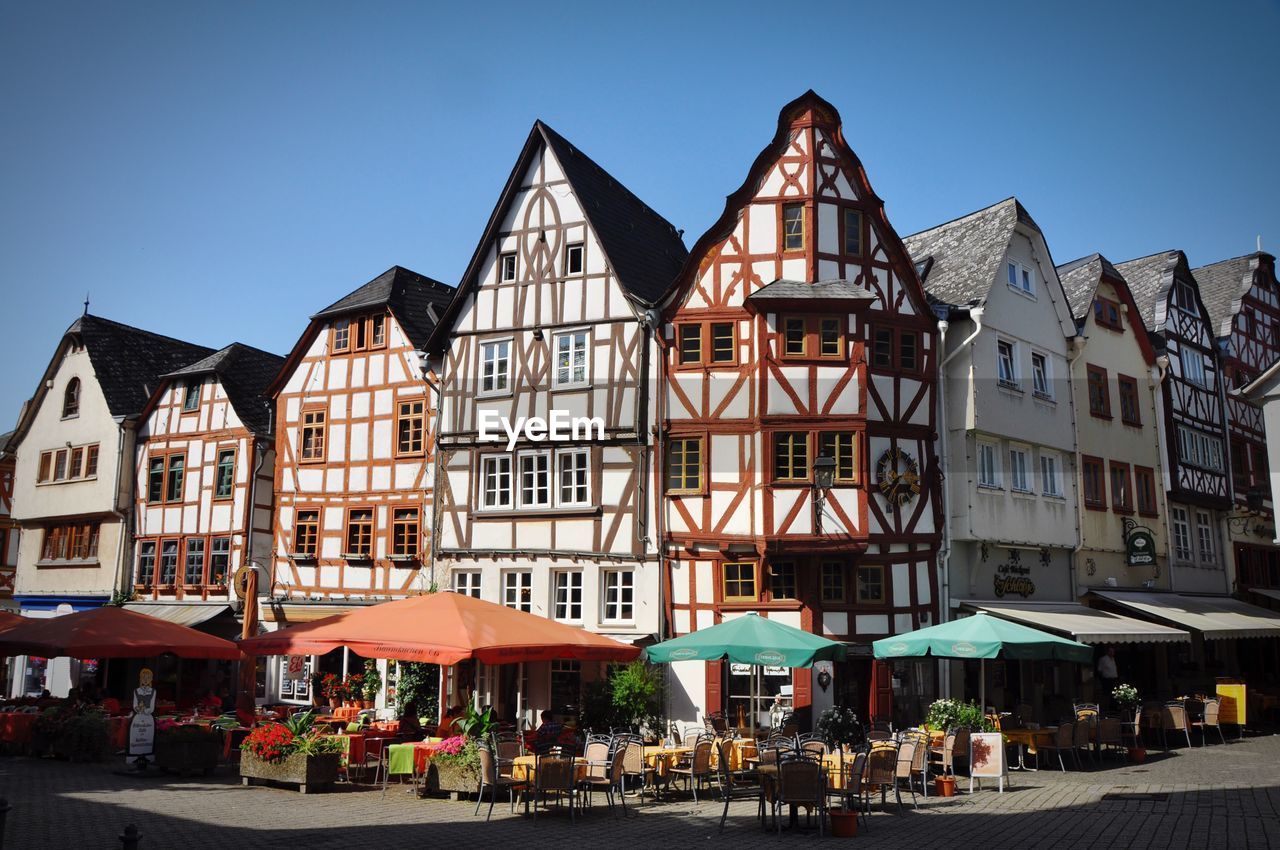 Half-timbered houses and groups of people in restaurant and cafes on main square of limburg, germany