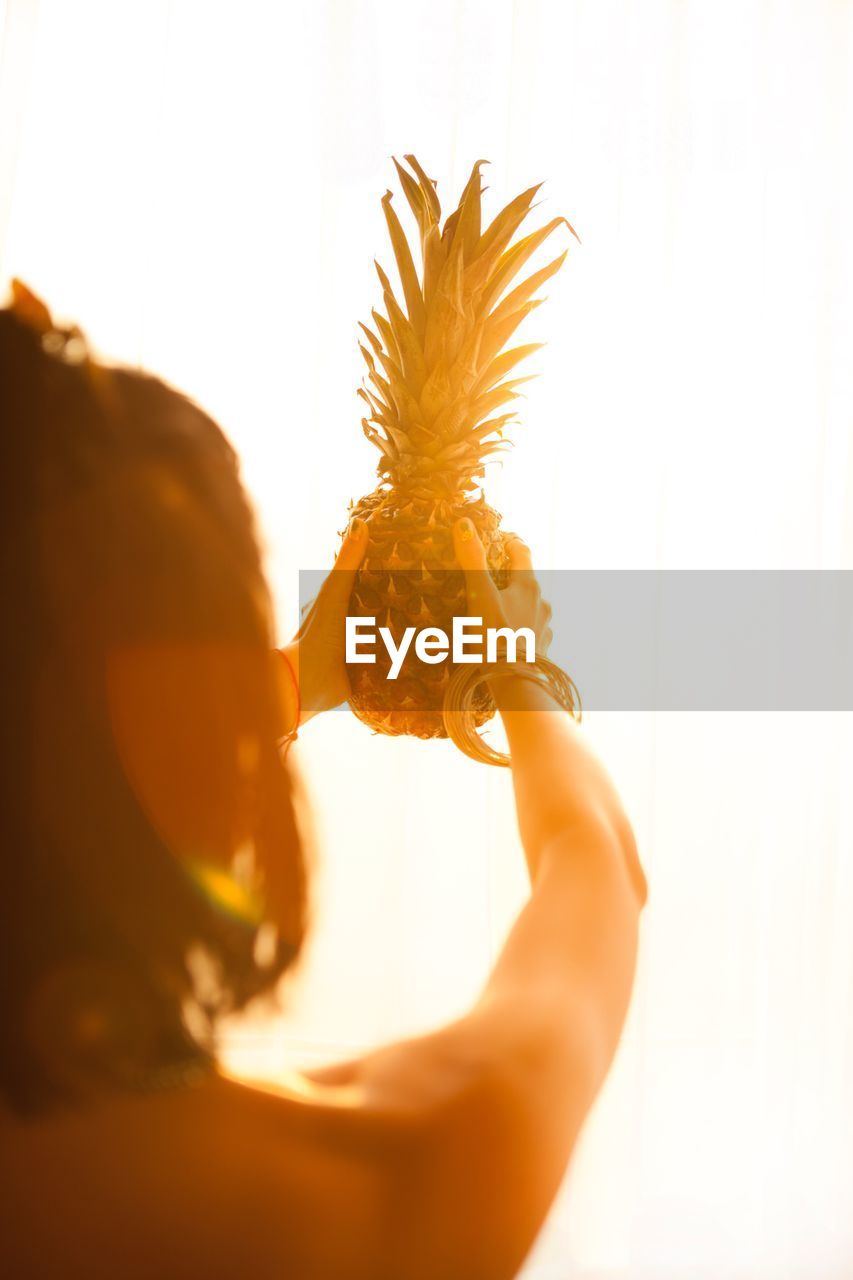 CROPPED IMAGE OF WOMAN HOLDING HANDS WHILE STANDING ON WOOD