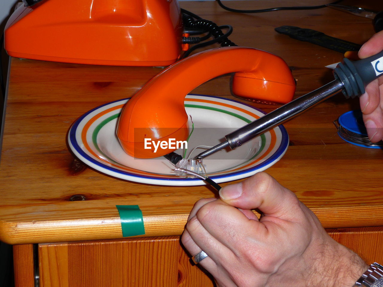 Cropped hands of man repairing telephone 