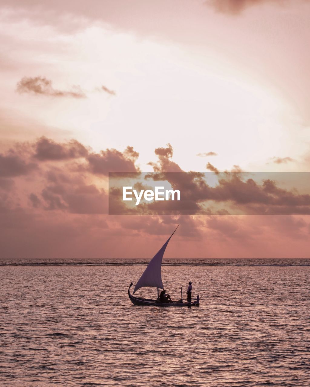 Silhouette men on boat in sea against sky during sunset