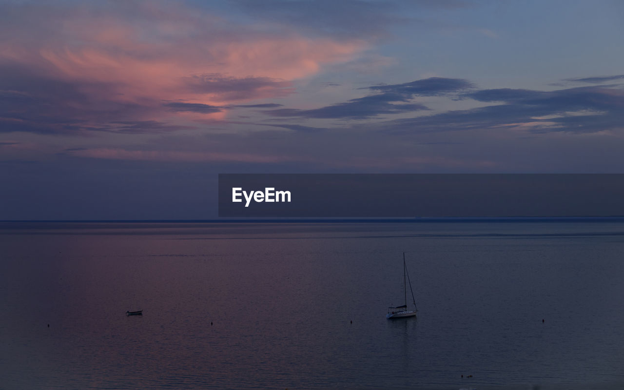 SAILBOAT ON SEA AGAINST SKY DURING SUNSET