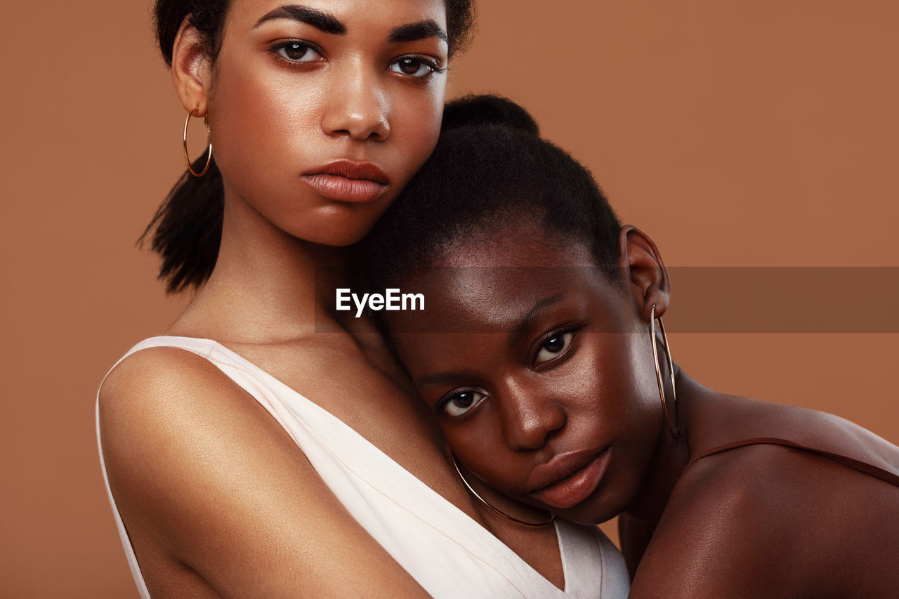 Portrait of females against brown background