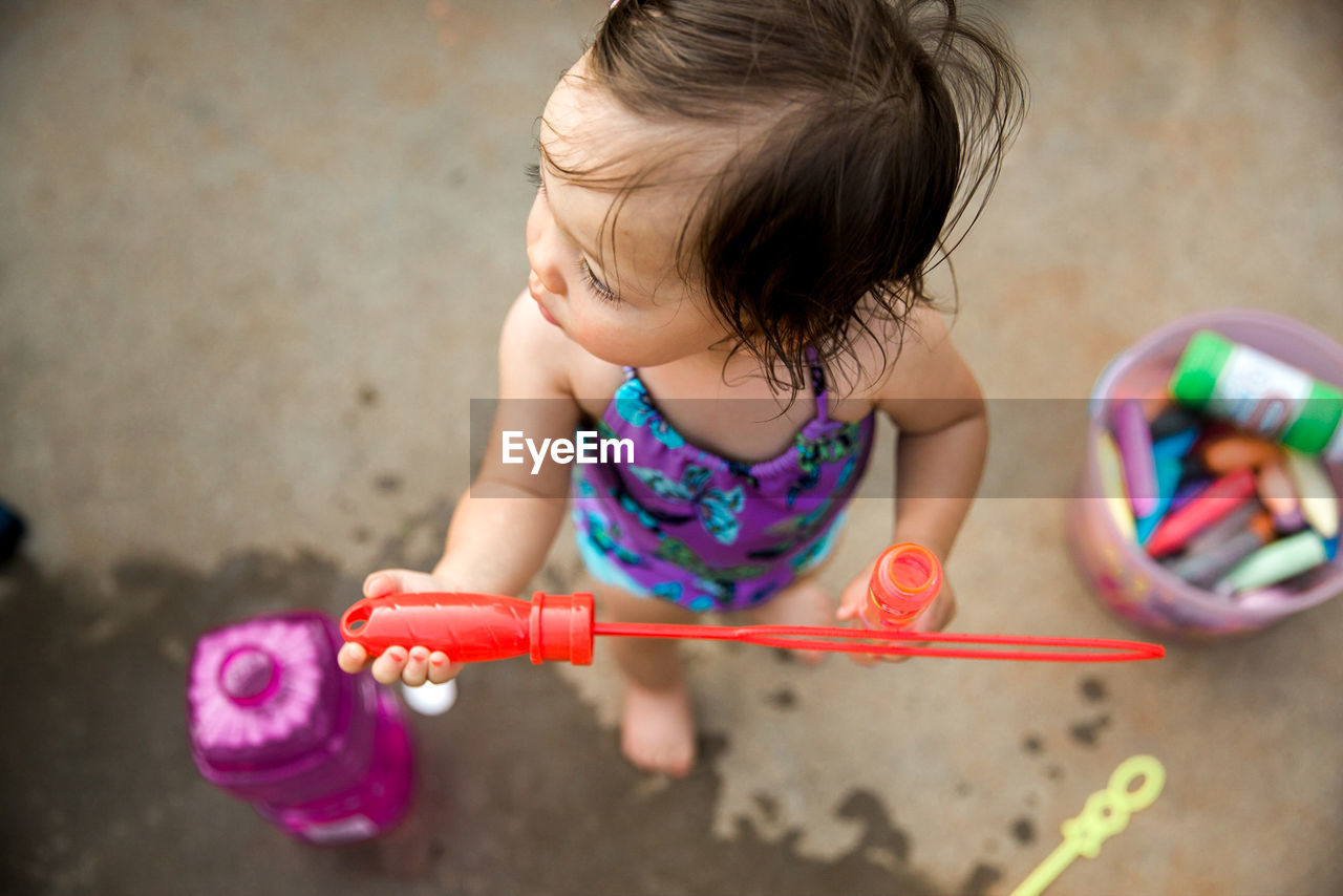 High angle view of girl playing with bubble wand