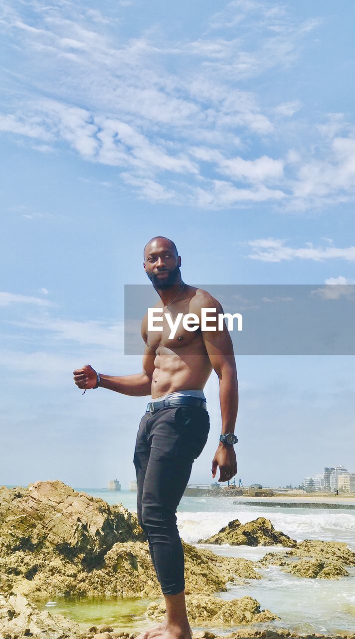 Full length of man standing at beach against sky