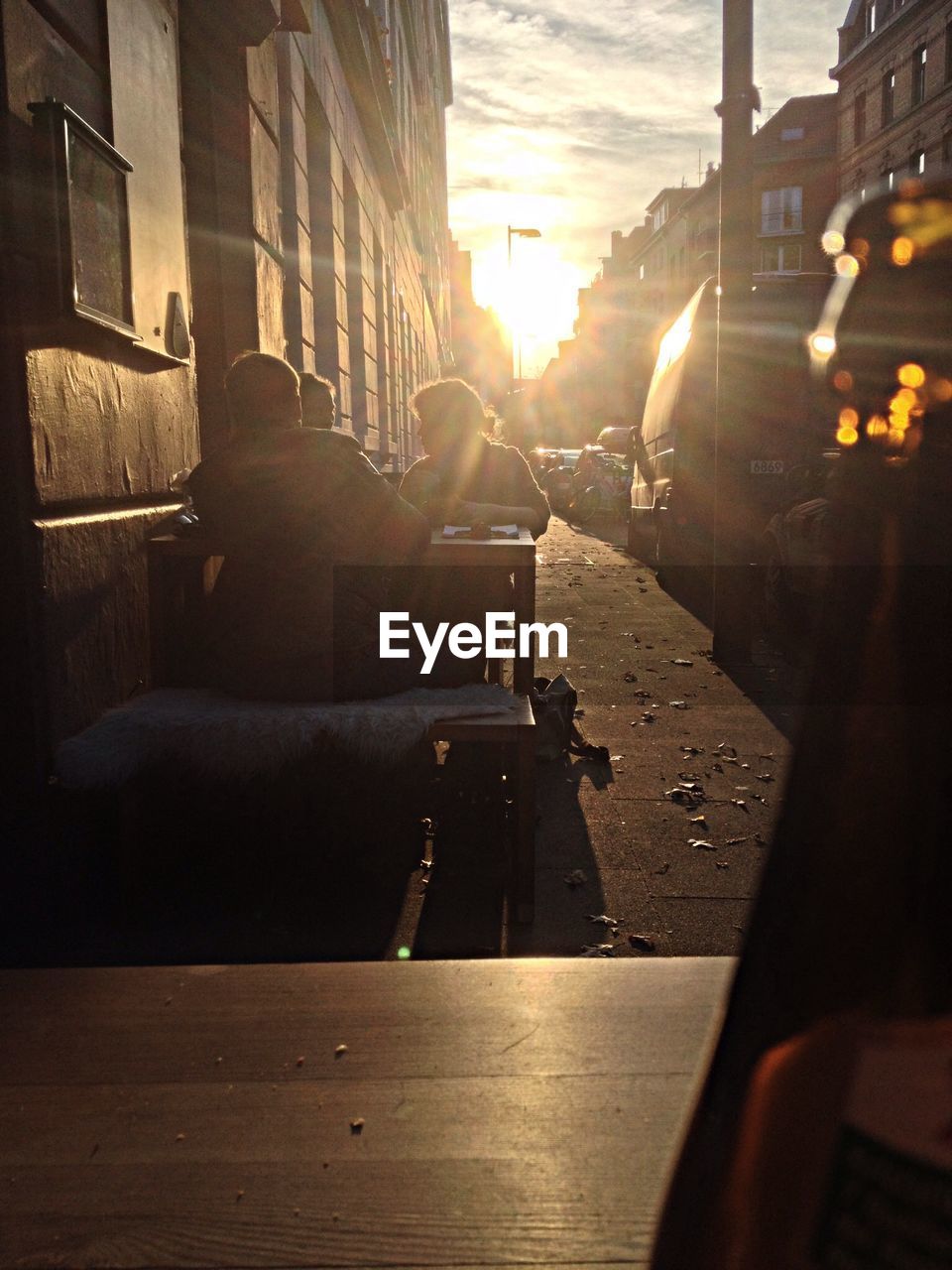 People sitting on sidewalk cafe during sunset