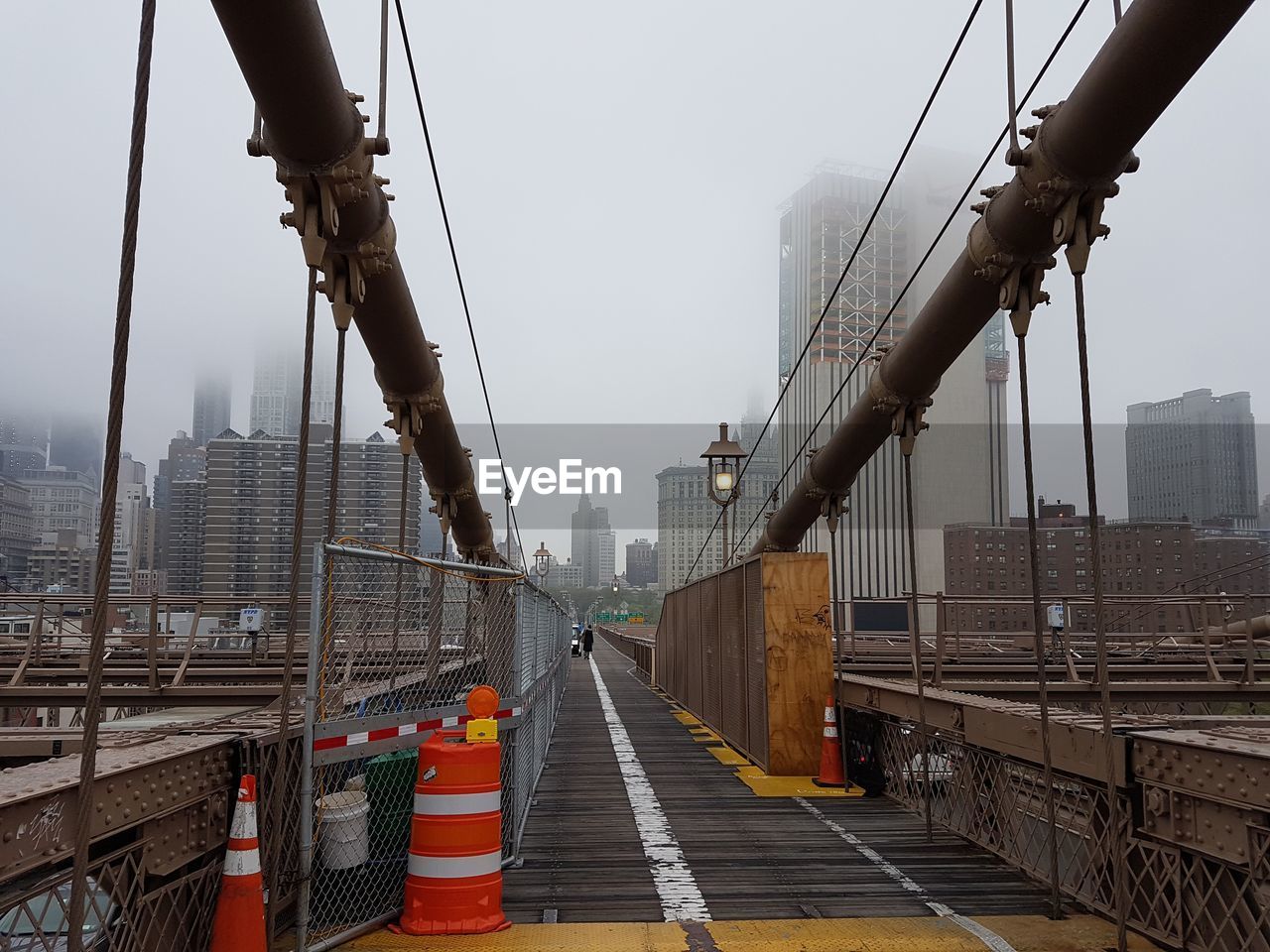 Bridge and buildings against sky during foggy weather