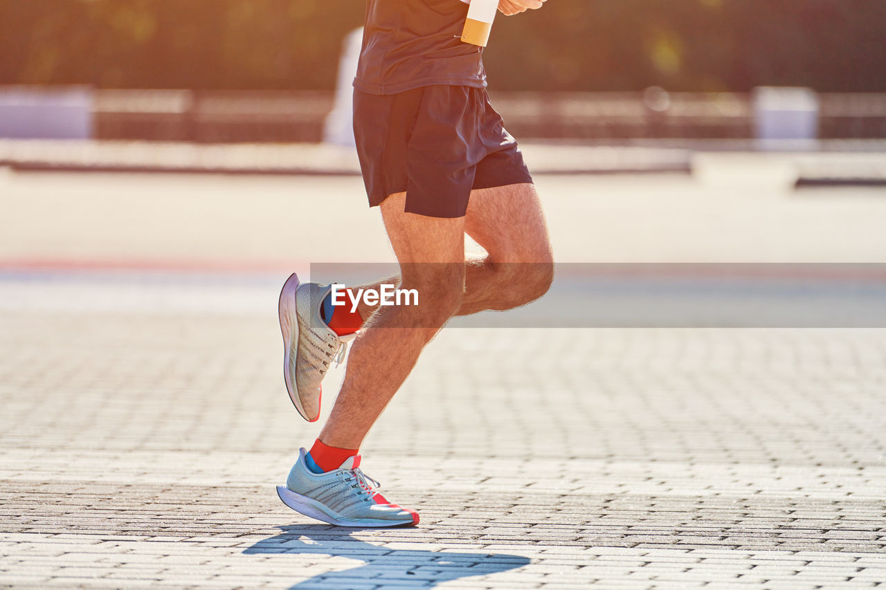 Running man. athletic man jogging in sportswear on city road. healthy lifestyle, fitness sport hobby