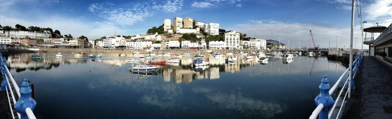 BOATS IN HARBOR WITH BUILDINGS IN BACKGROUND