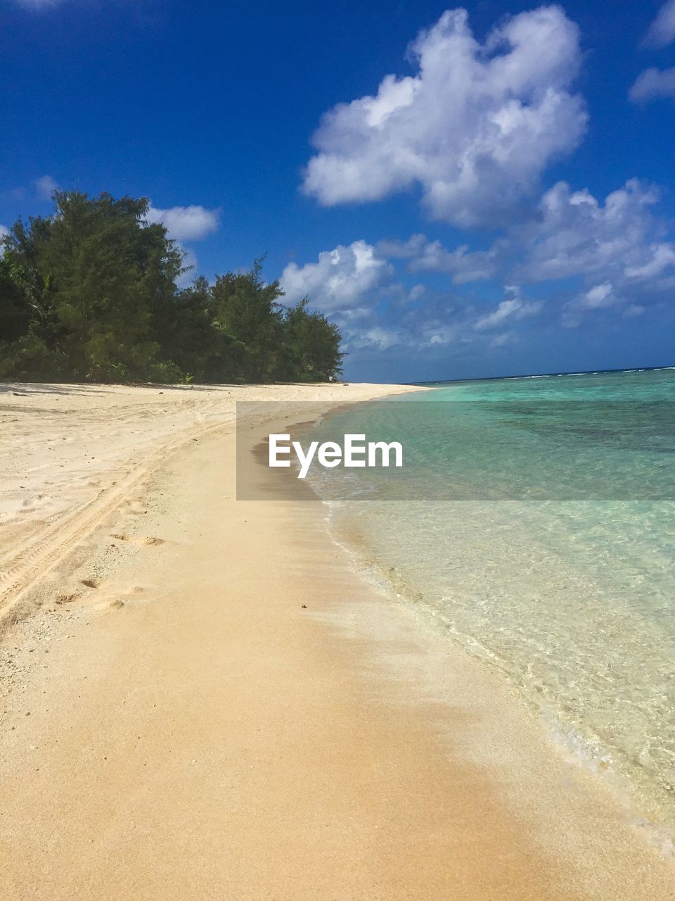 Scenic view of beach against cloudy sky