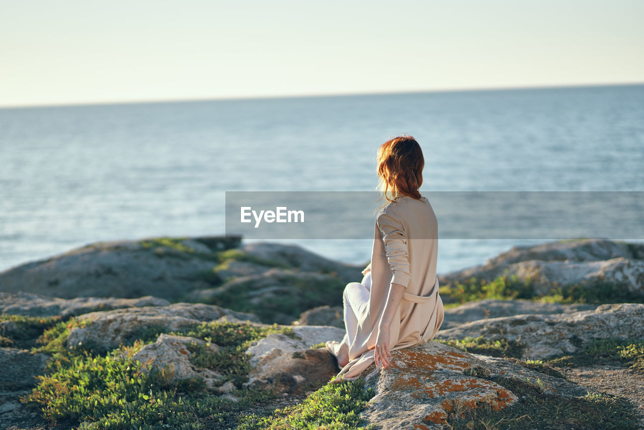 Rear view of woman looking at sea against sky