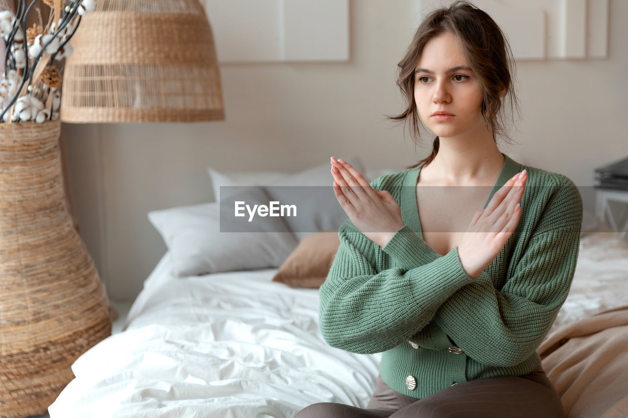 young woman sitting on bed