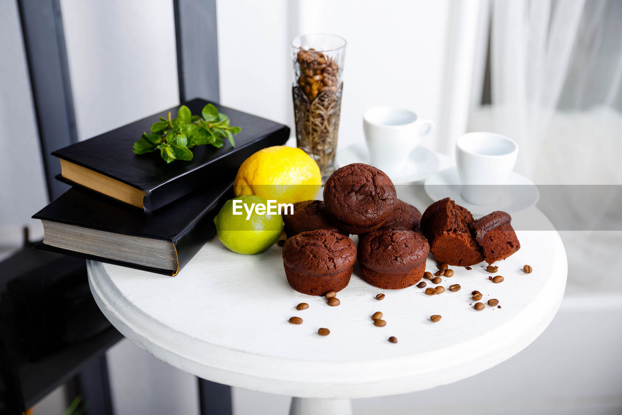 Chocolate cupcakes with coffee beans on a white wooden table