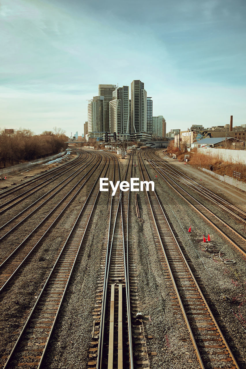 Railroad tracks in city against sky