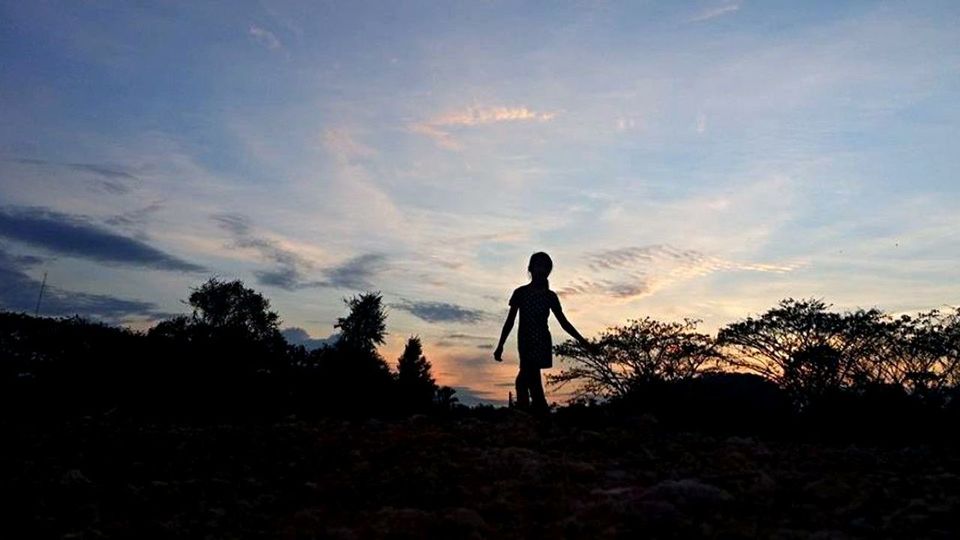 SILHOUETTE OF PEOPLE STANDING ON LANDSCAPE AT SUNSET