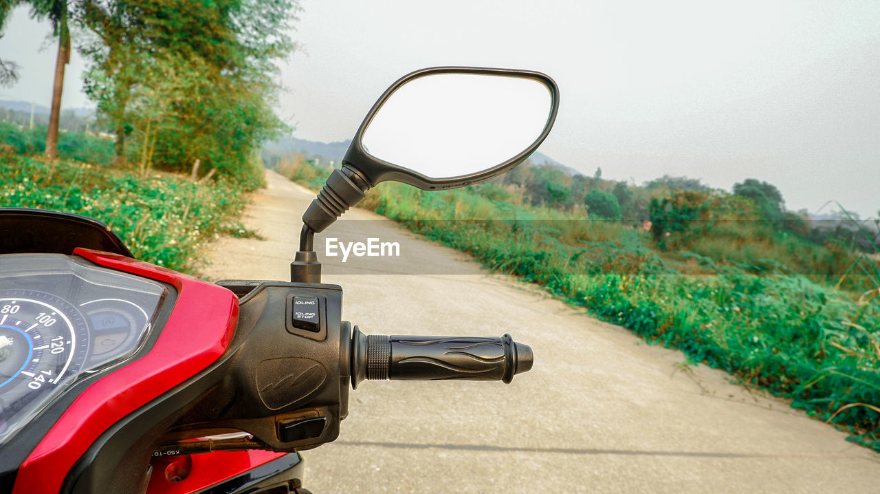 MOTORCYCLE ON ROAD AMIDST TREES