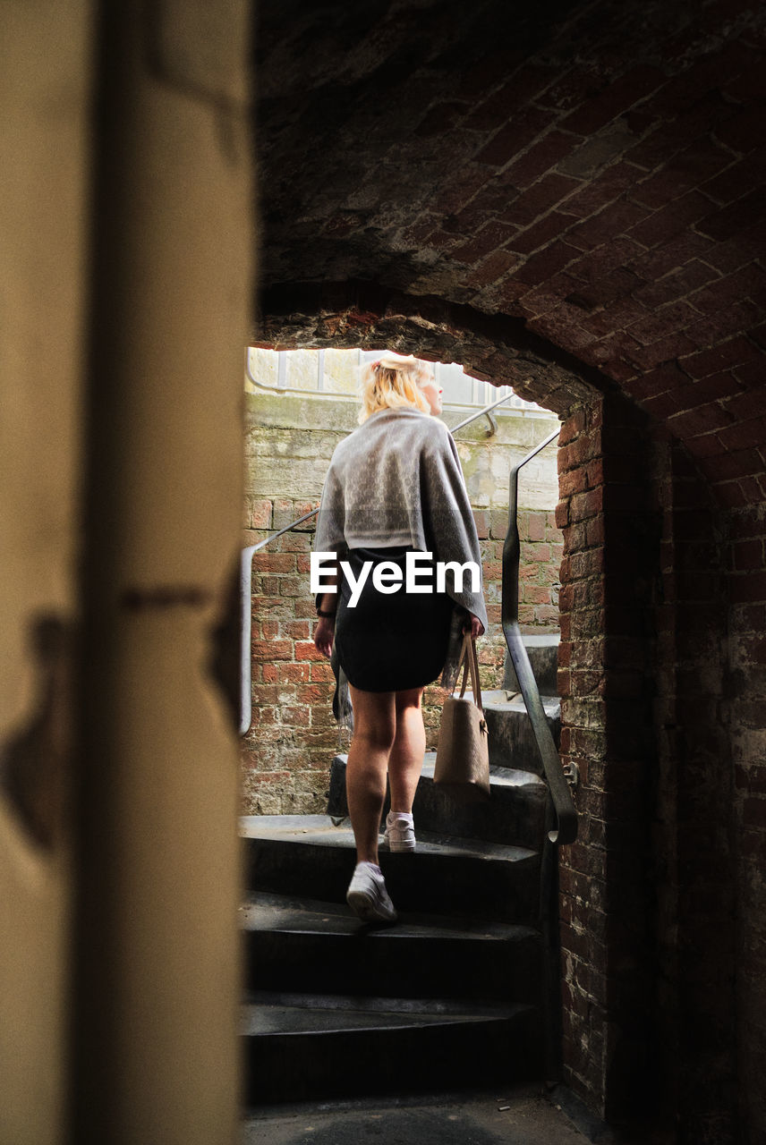 Rear view of woman walking on staircase in building