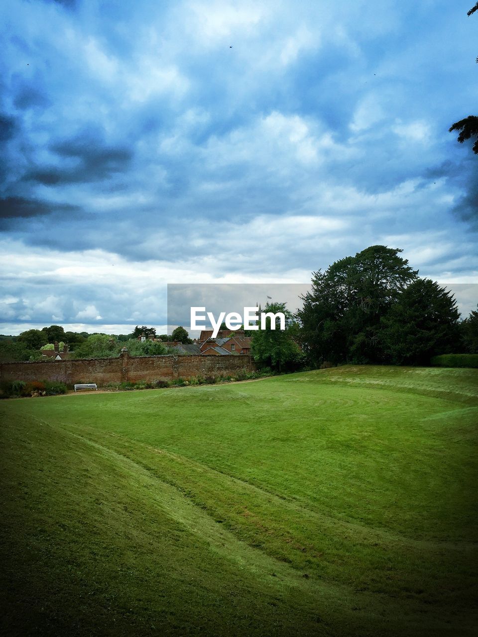 Scenic view of grassy field against cloudy sky