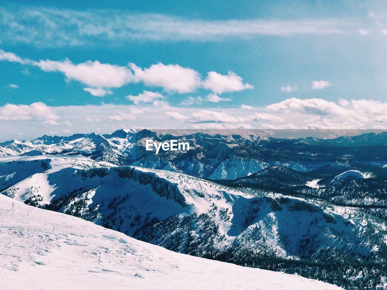 Scenic view of snowcapped mountains against blue sky