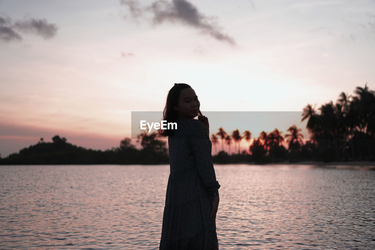 Smiling woman in silhouette at sunset