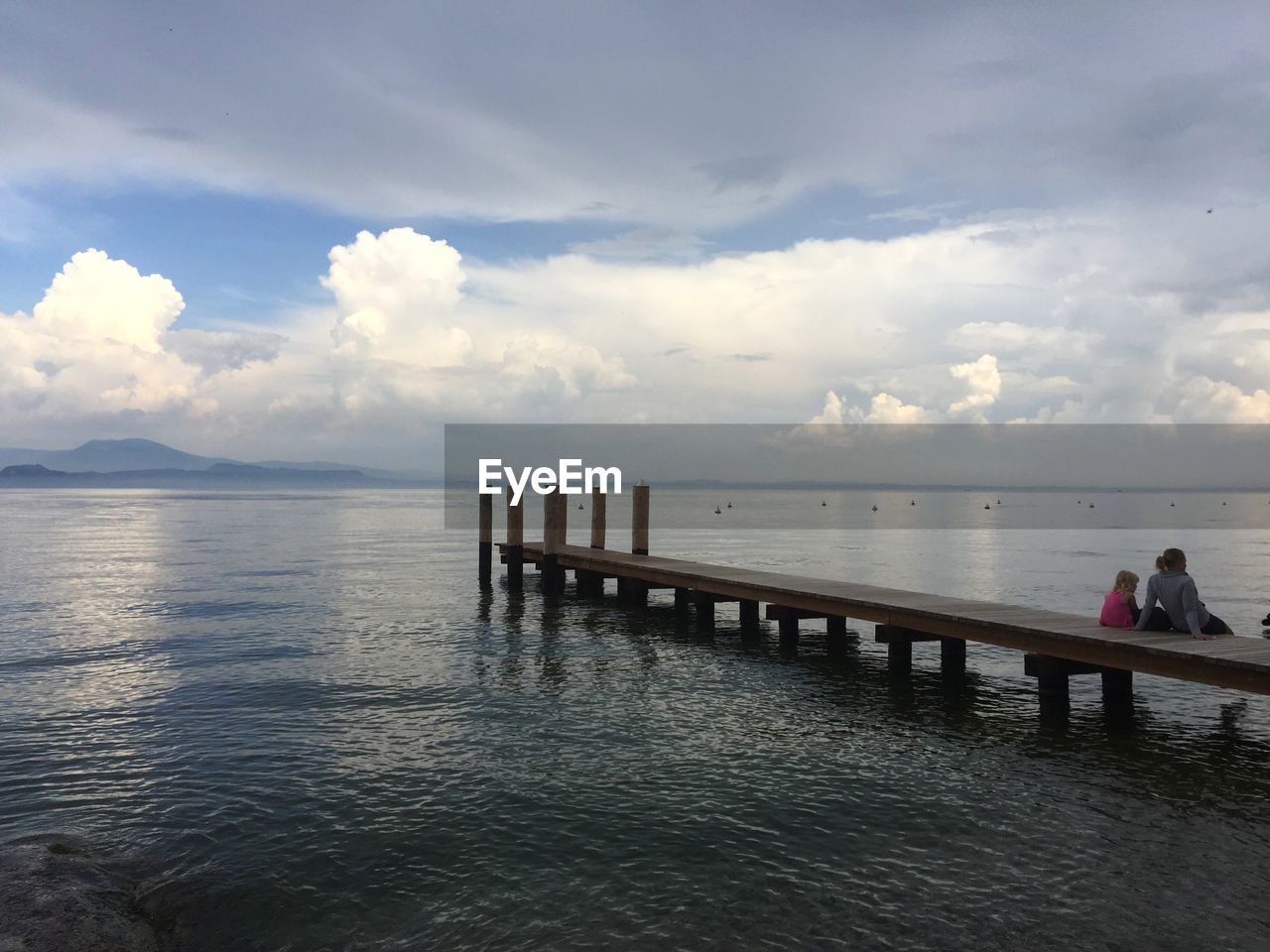 PIER ON SEA AGAINST CLOUDY SKY