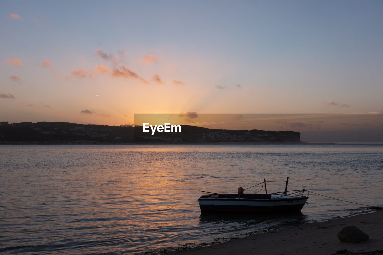 Fishing boats on a river sea at sunset in foz do arelho, portugal