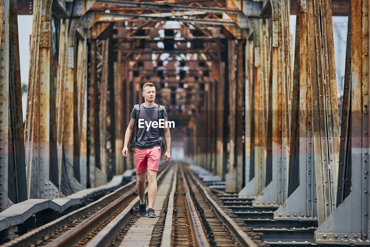 Man walking on railway bridge