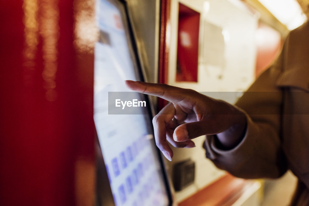 Woman using ticket machine at subway station