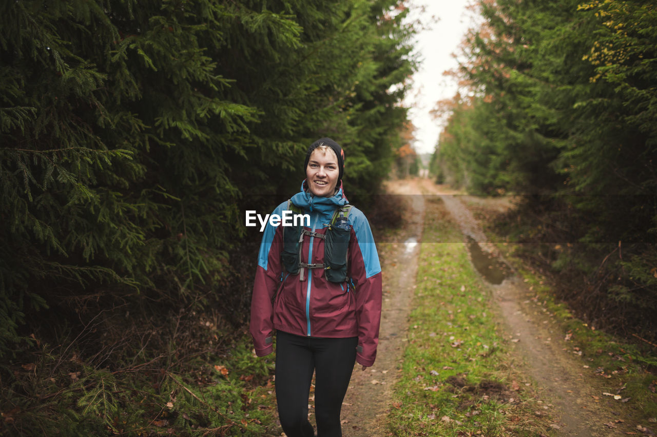 Woman walking through autumn forest