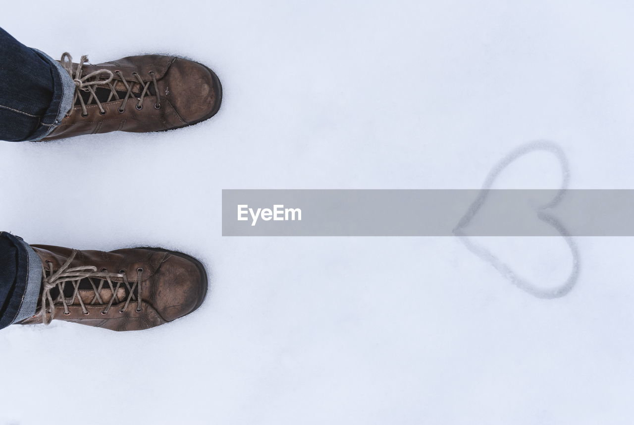 Low section of person standing on snow