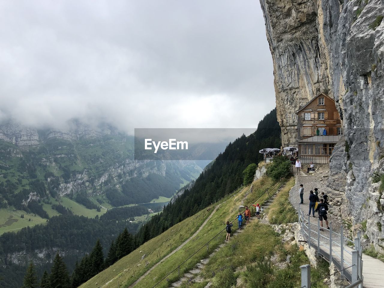 PEOPLE ON MOUNTAIN AGAINST SKY