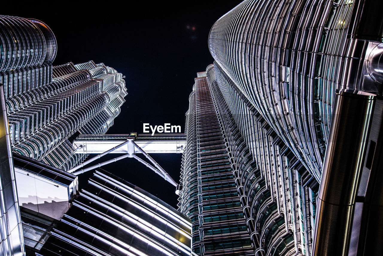 Low angle view of petronas tower against sky at night