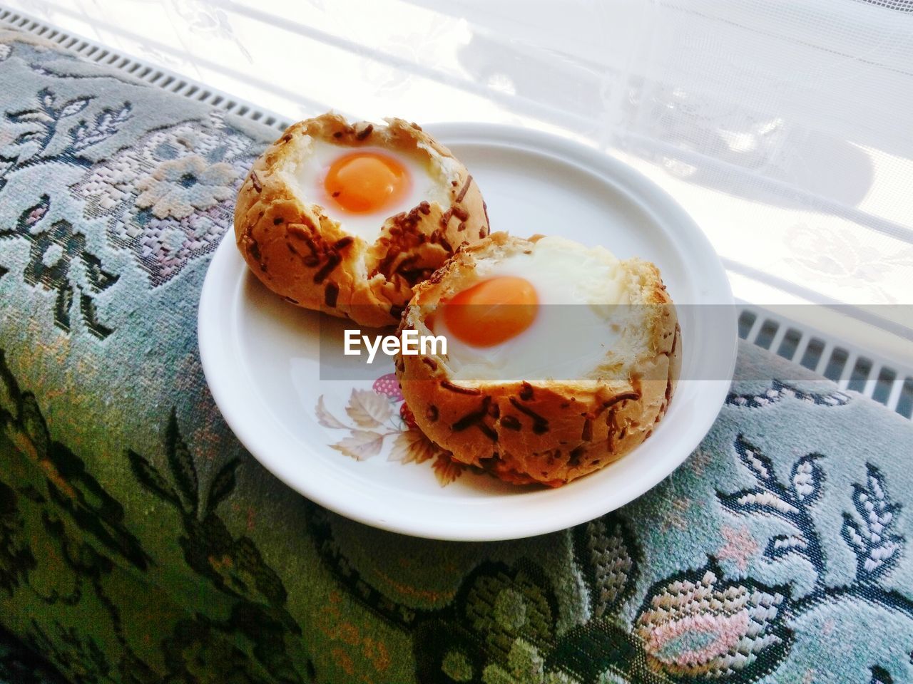 High angle view of food in plate on sofa by window