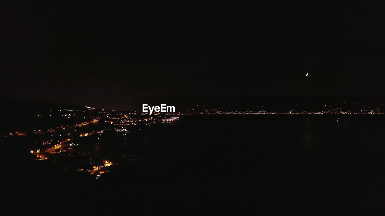 VIEW OF ILLUMINATED CITYSCAPE AT NIGHT