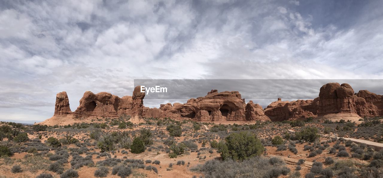 Rock formations on landscape against cloudy sky
